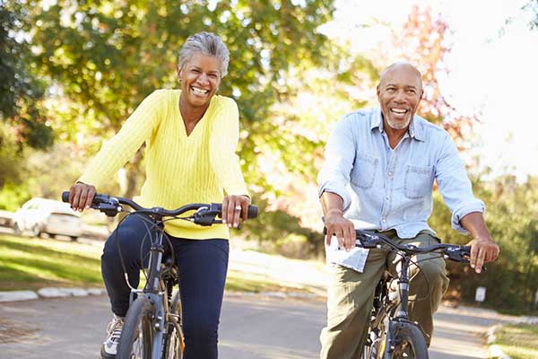 Senior couple riding bicycles - Dread Disease Insurance